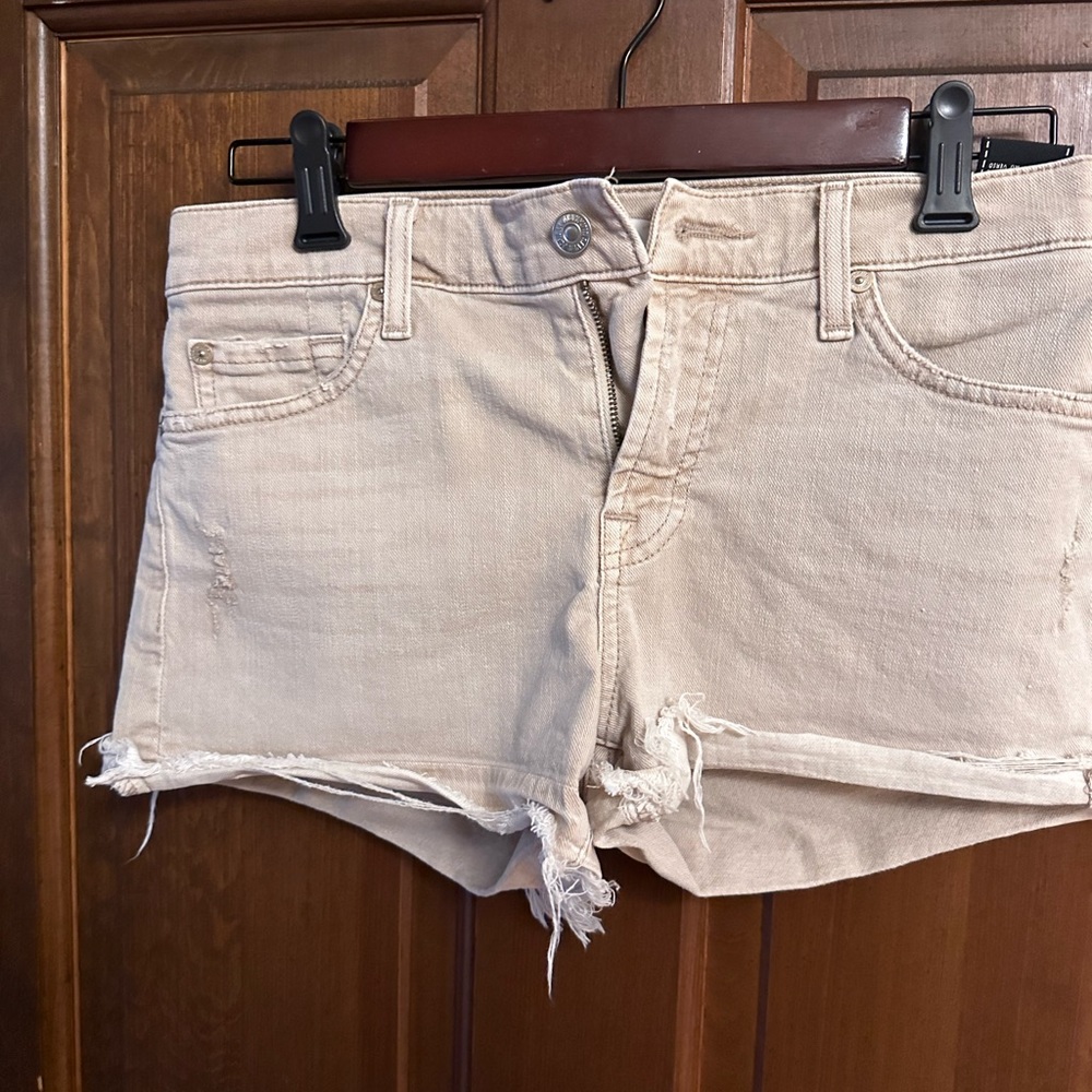 Beige distressed denim shorts